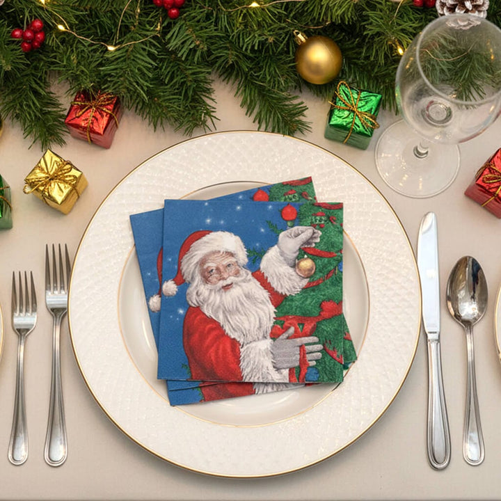 Brightly coloured Christmas tree and Santa design table napkins on a plate with Christmas decorations