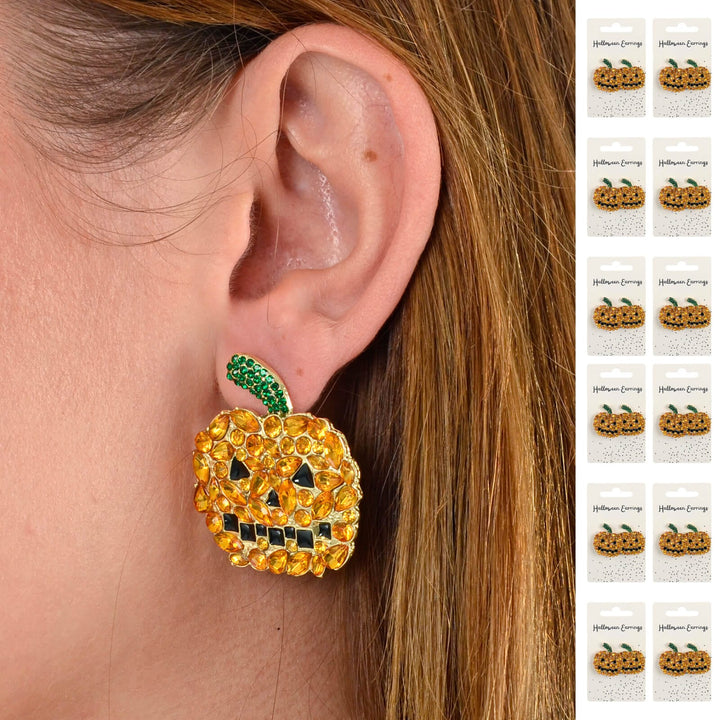 Pumpkin-shaped earring with rhinestones worn by a person with a close-up of the earring.