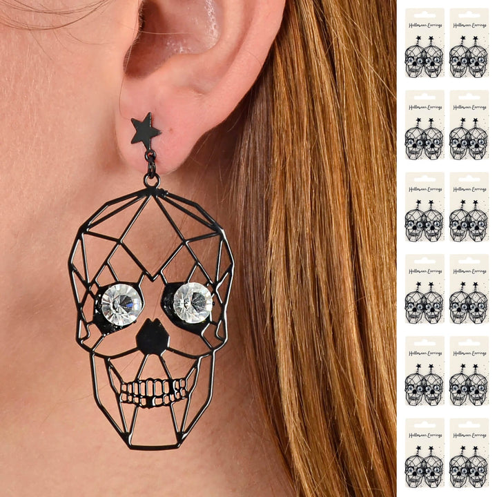 Black skull-shaped earring with crystal eyes worn by a person with a side view of the ear.