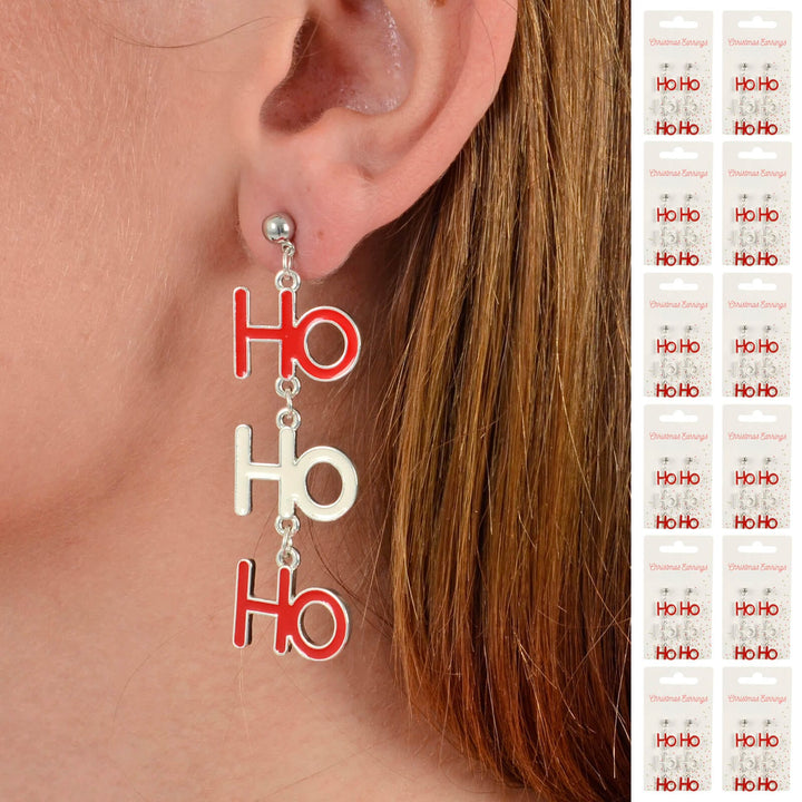 Person wearing a Ho Ho Ho Christmas earring with 12 cards of earrings down one side