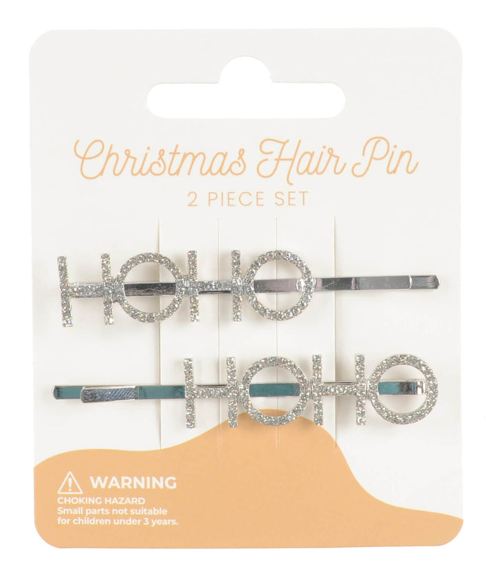 Two silver Ho HO hair pins on a white card with &