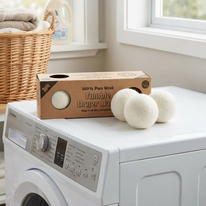Wool dryer balls and packaging on a washing machine in a laundry room.