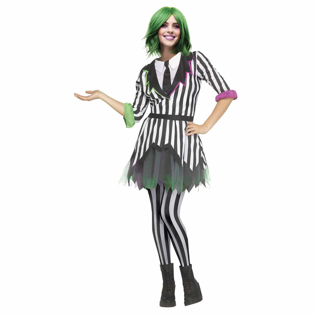 A woman modeling a costume dress with black and white vertical stripes, a black tie, striped tights, green hair, and green and purple accents, photographed against a plain white background.