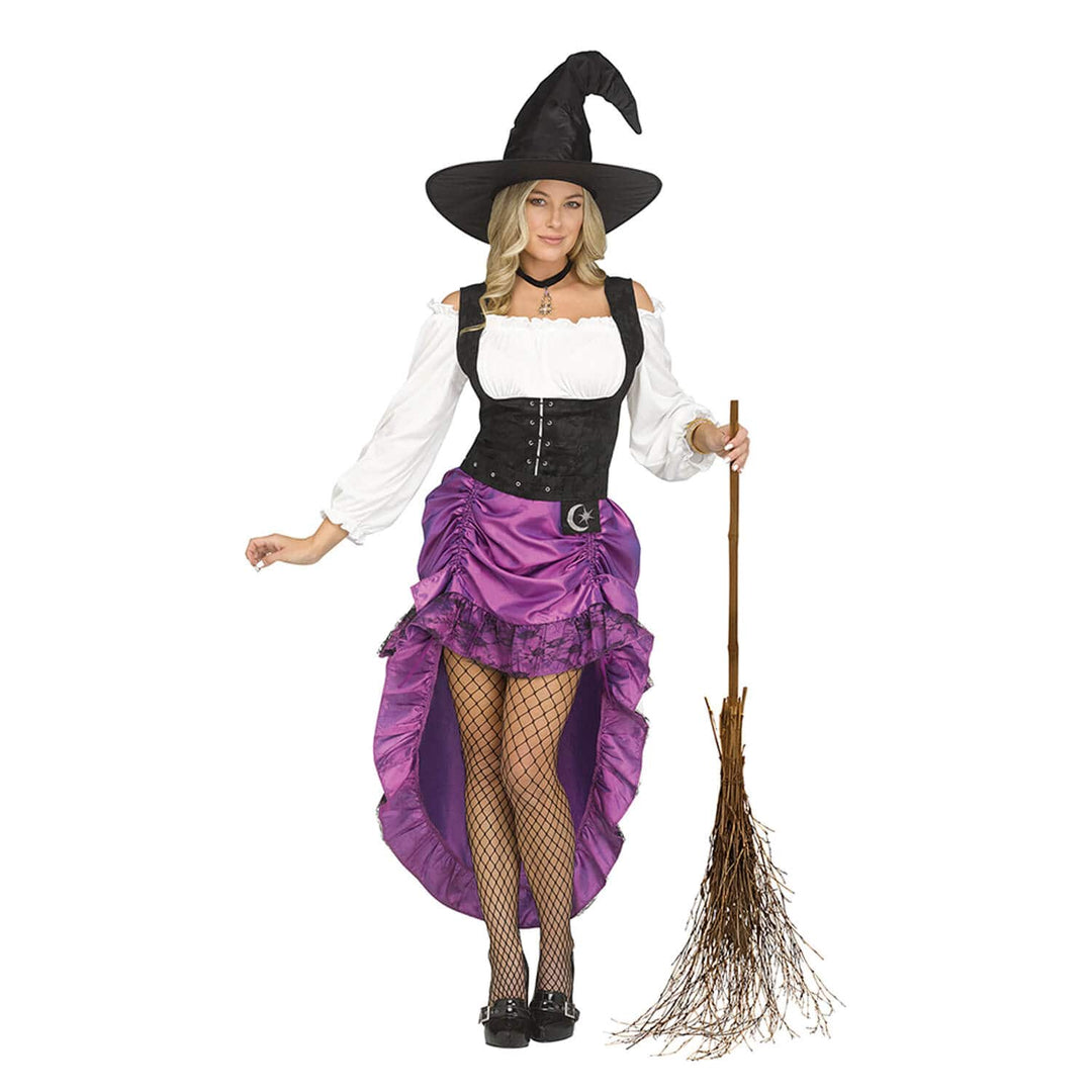 A woman modeling a witch costume on a plain white background, holding a small broom. The costume includes a black pointed witch hat, a white off-the-shoulder blouse, a black corset-style bodice, a purple ruffled high-low skirt with a black lace overlay and a silver crescent moon detail, fishnet tights, and black shoes.