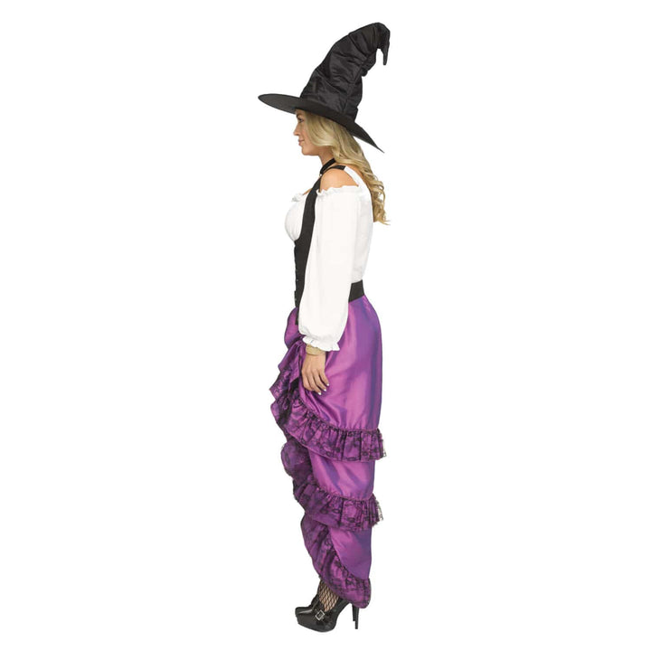 A woman modeling a witch costume consisting of a black pointed hat, a white off-the-shoulder blouse, a black vest, and purple ruffled pants, shown in profile against a plain white background.