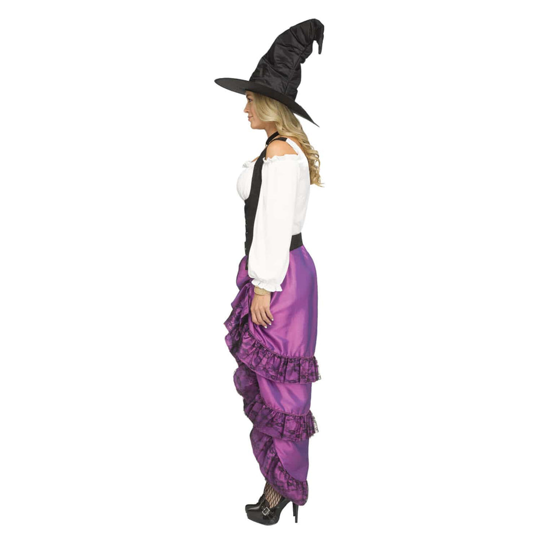 A woman modeling a witch costume consisting of a black pointed hat, a white off-the-shoulder blouse, a black vest, and purple ruffled pants, shown in profile against a plain white background.