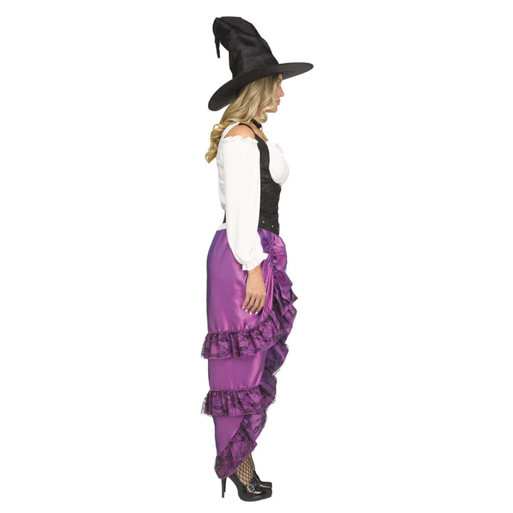 A woman modeling a vintage-style witch costume, shown in profile against a solid white background. The costume includes a black pointed witch hat, a white long-sleeve top with a black corset-style vest, and a long purple ruffled skirt.