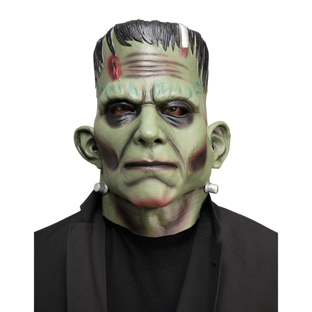 Frankenstein monster mask with green skin and black hair on a white background