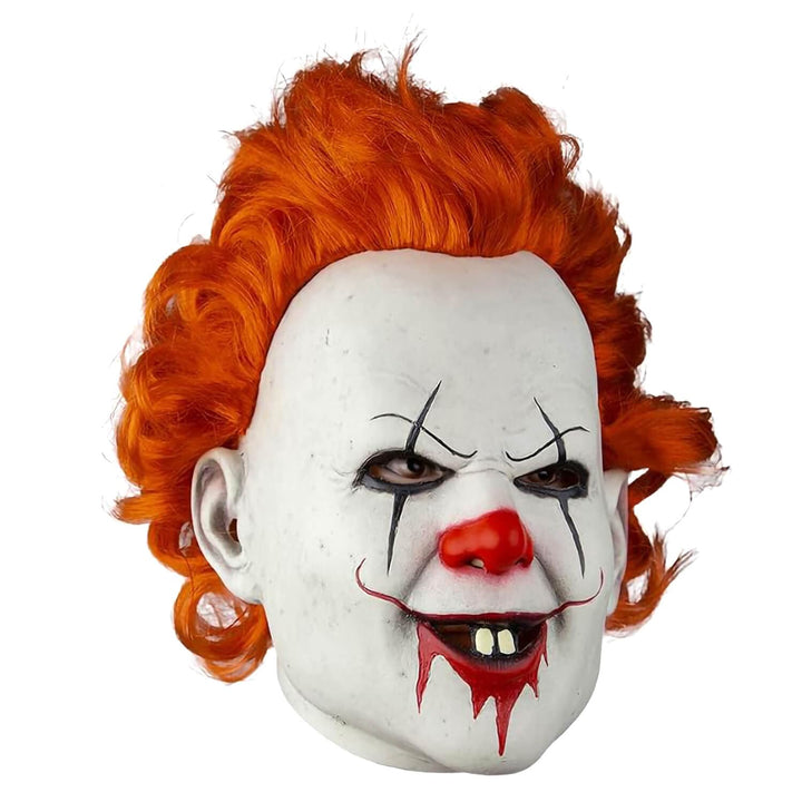A Pennywise clown mask with bright orange hair, white face paint, a red nose, and dripping red smile, shown on a plain white background.