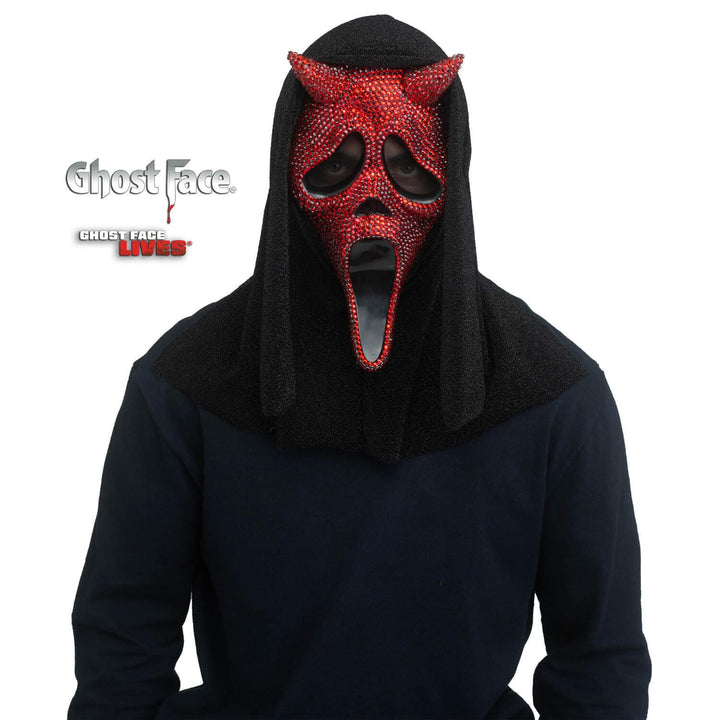 Person wearing a horned Devil design Ghost Face mask with red rhinestones  and a black hood on a white background