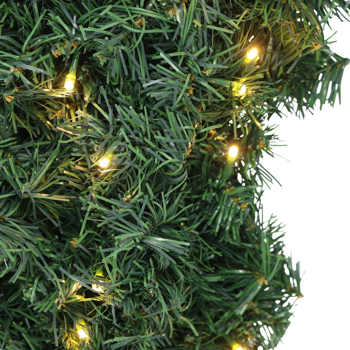 Green artificial Christmas tree with small lights on a white background