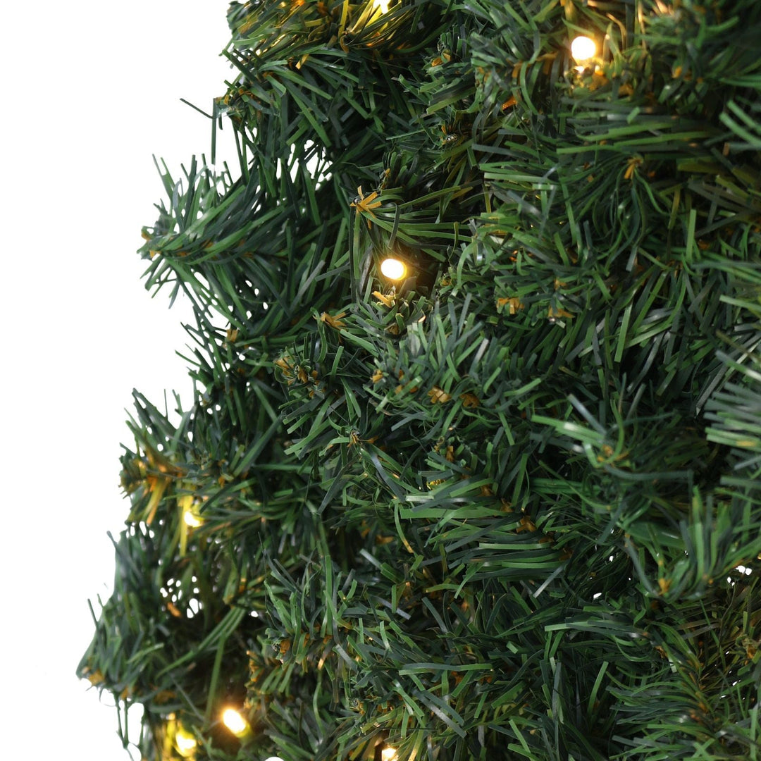 Close-up of a Christmas tree with lights on a white background