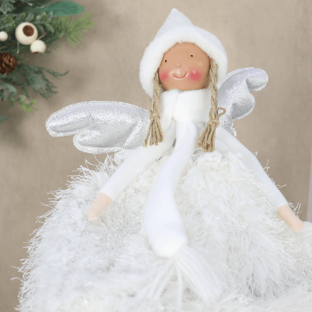 angel tree topper in front of christmas wreath and nude colour background