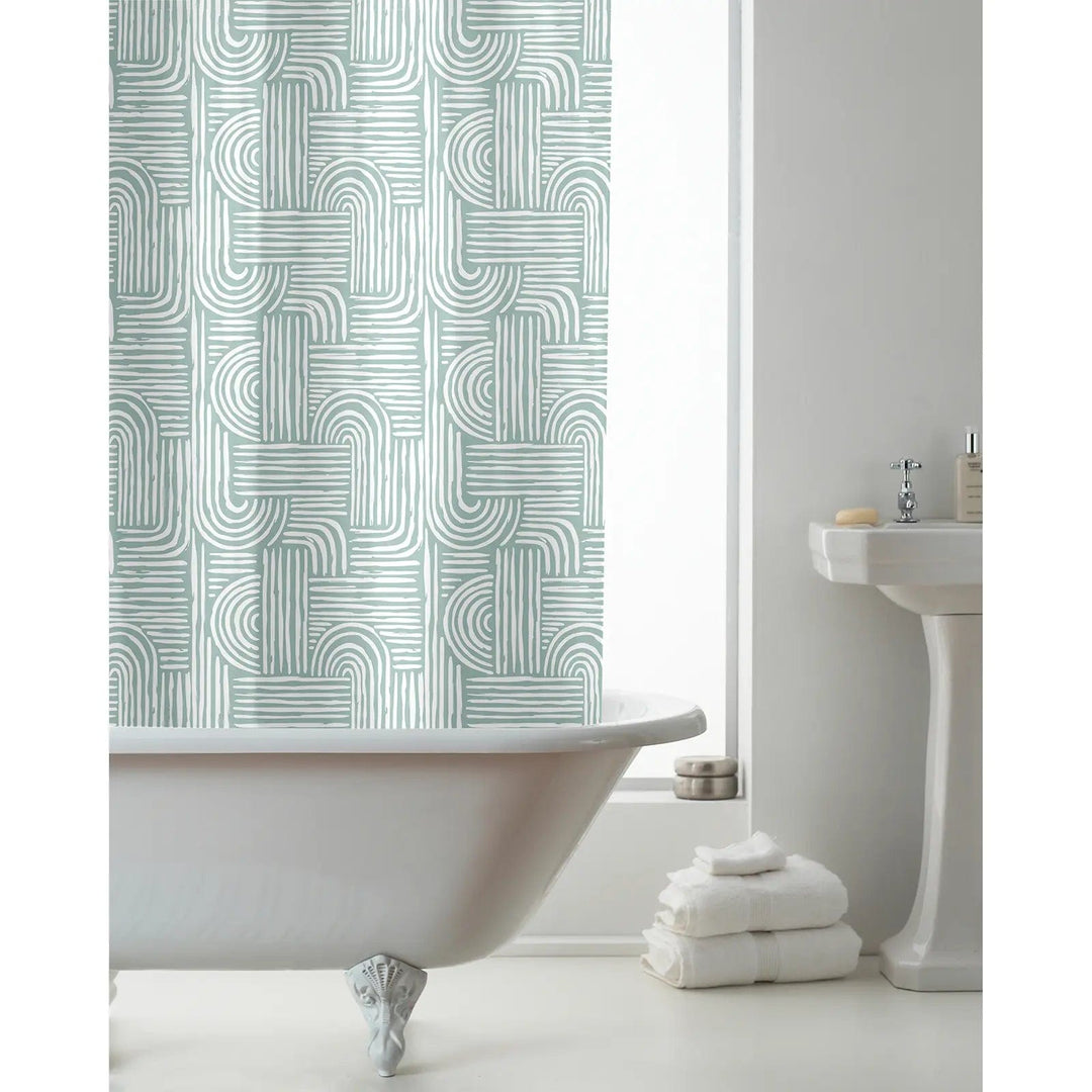 Boho green and white pattern shwer curtain hanging over a bath with towels and washbasin