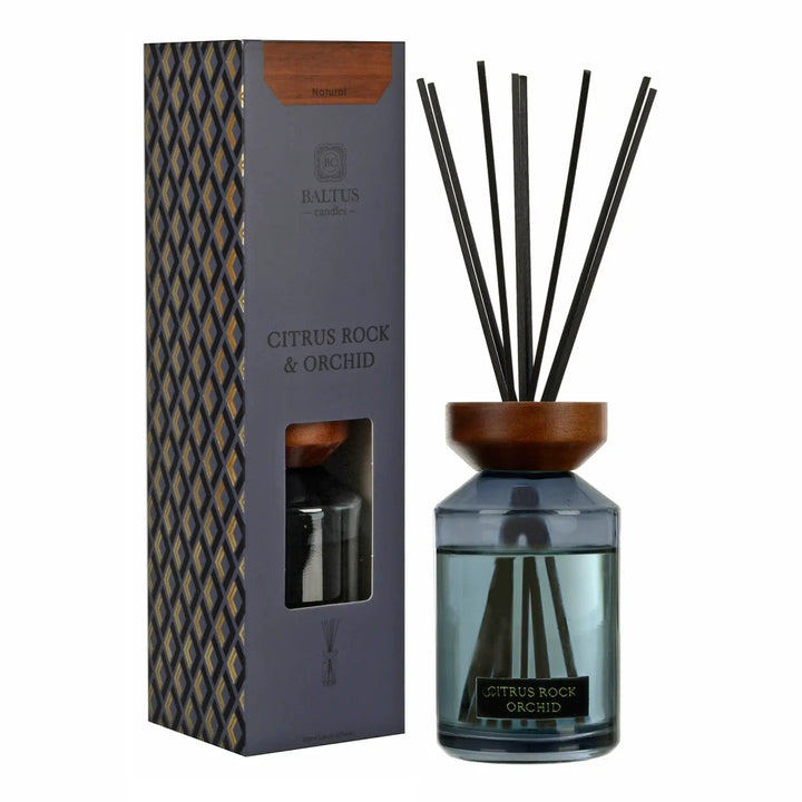 Citrus Rock & Orchid scented reed diffuser with wooden top and black reeds next to gift box packaging