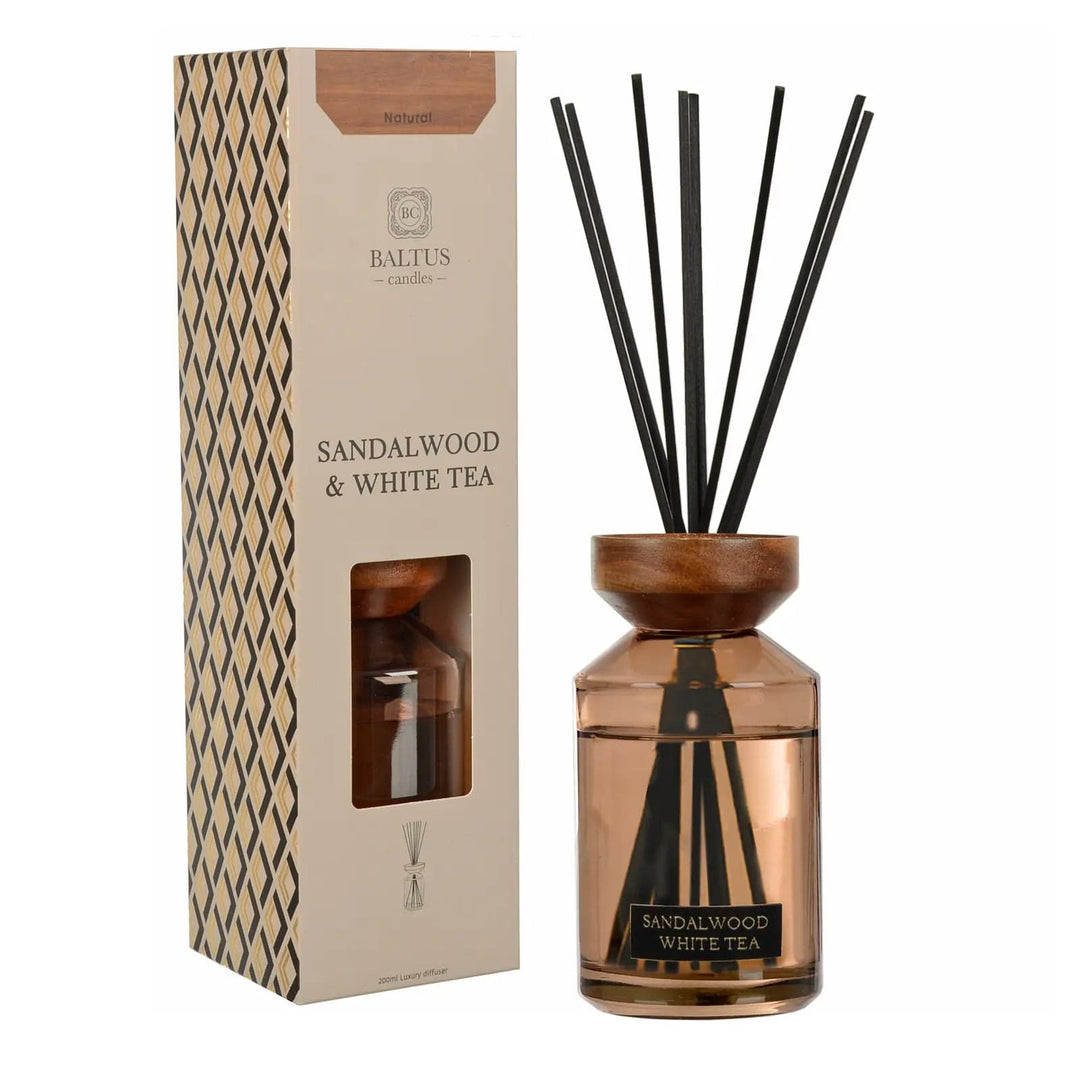 Sandalwood & White Tea scented reed diffuser with wooden top and black reeds next to gift box packaging