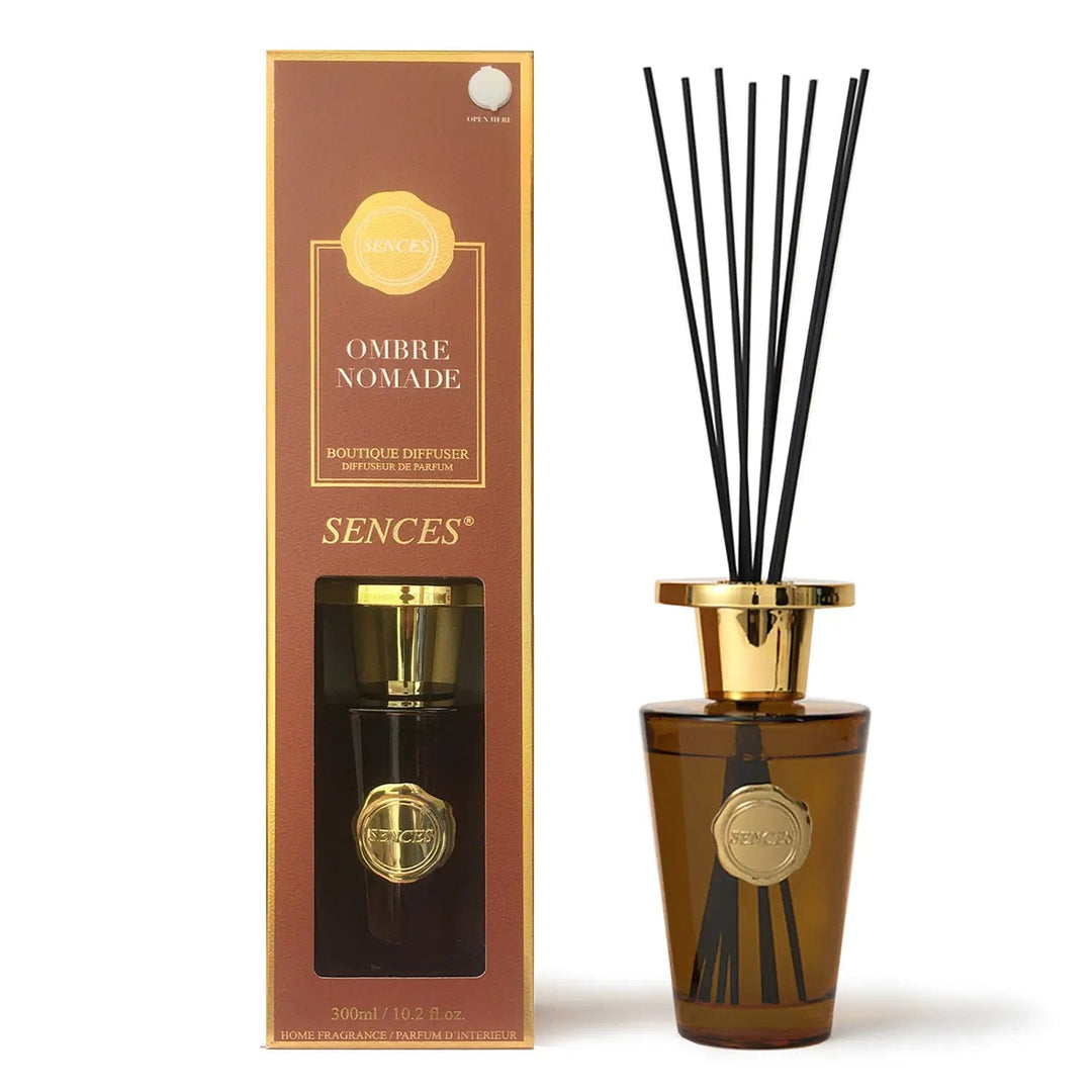 Ombre Nomade scented diffuser in chestnut brown pack with gold top bottle and black reeds