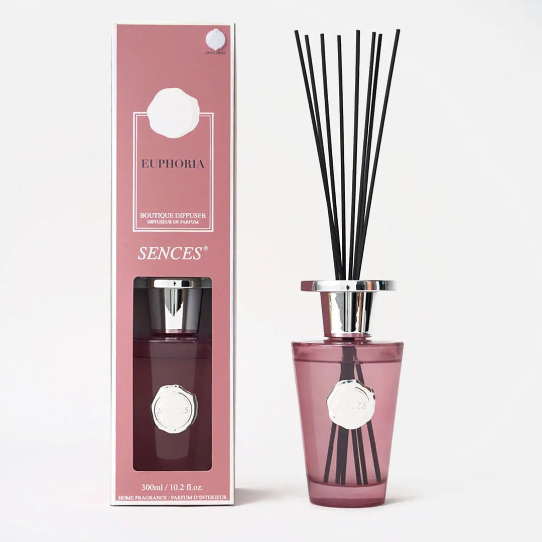 Euphoria scented reed diffuser in pink packaging with silver top bottle and black reeds