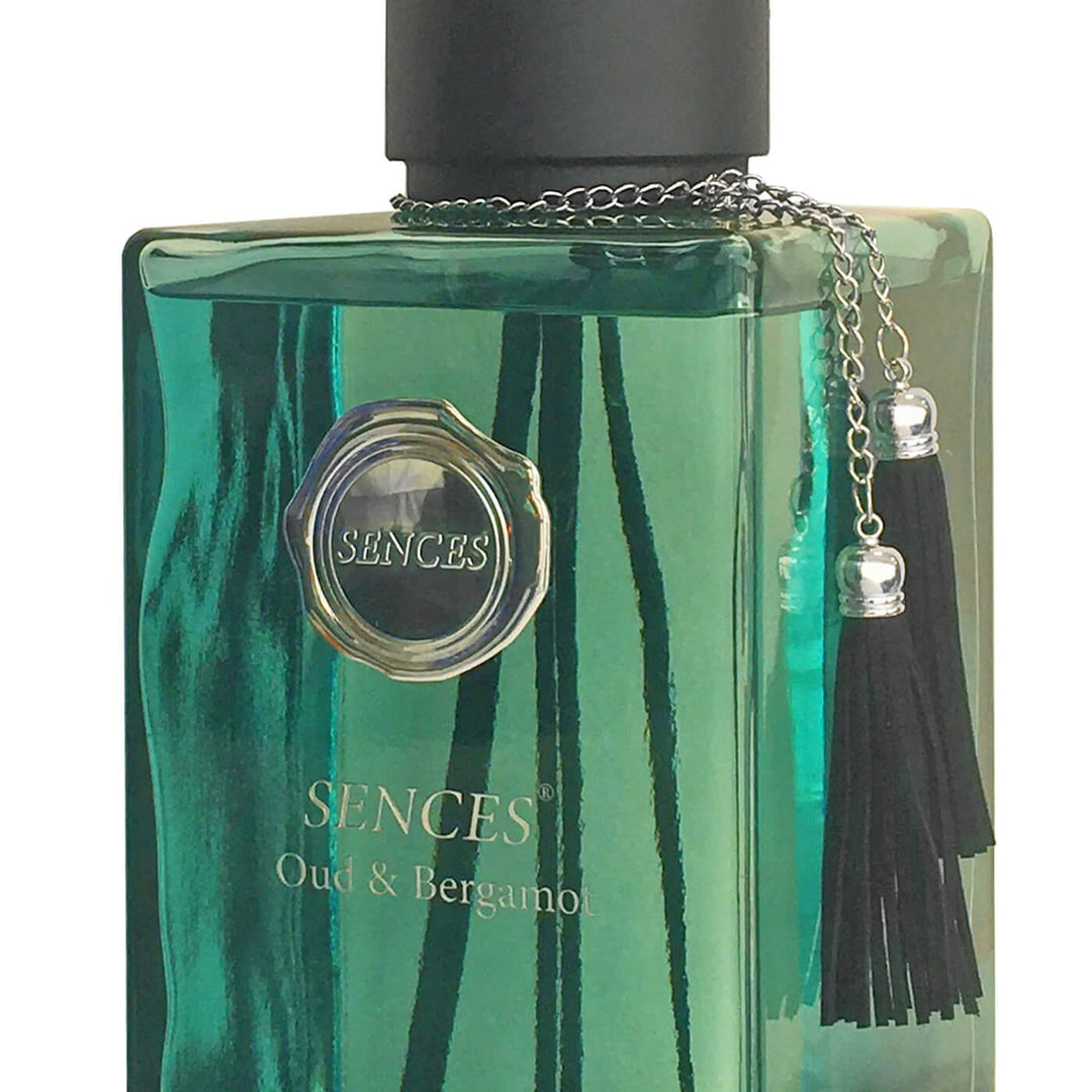Green perfume bottle with black cap and tassel on a white background