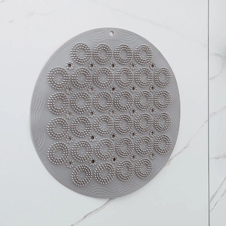 Grey body scrubber attached to a tiled wall in a shower room