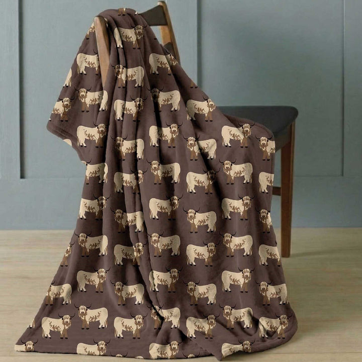 highland cow blanket draped over chair in room with panelled walls and wooden floor