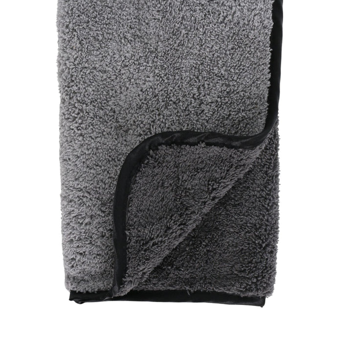 Gray microfibre towel with black trim on a white background