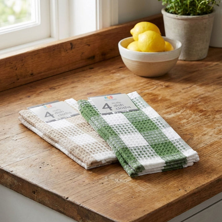 Set of dish towels on a wooden surface with a bowl of lemons in the background.