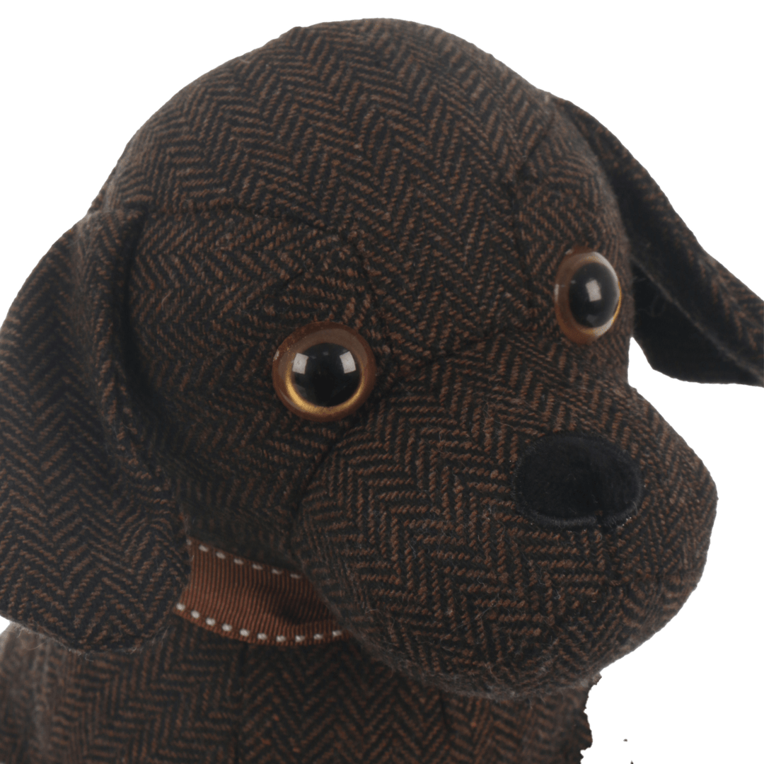 detail show of door stop dog face featuring beaded eyes and plush black nose with embroidered edge