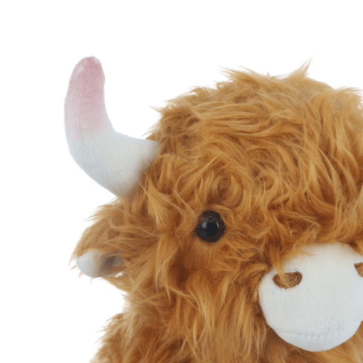 detail shot of highland cow beaded eyes and plush white horns