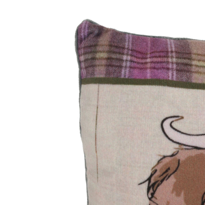 Close-up of a draught excluder with plaid edge and highland cow character on a white background