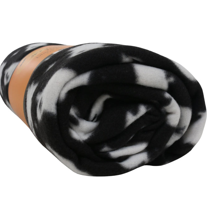 A rolled fleece blanket with a black and white ghost patter, wrapped in an orange paper band, on a solid white background.