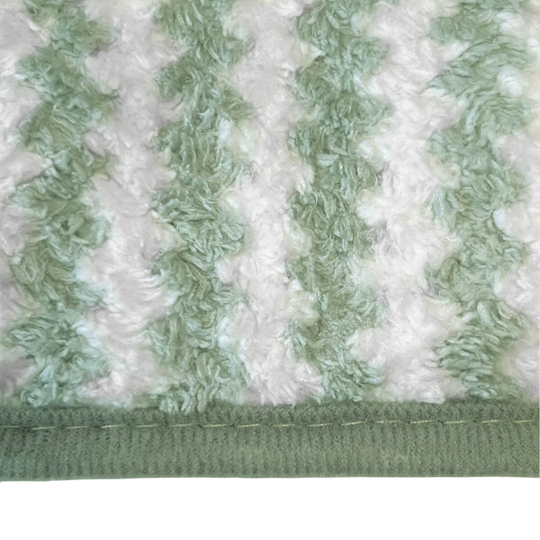 Close up of a microfibre cloth with green and white stripes and green bound edge