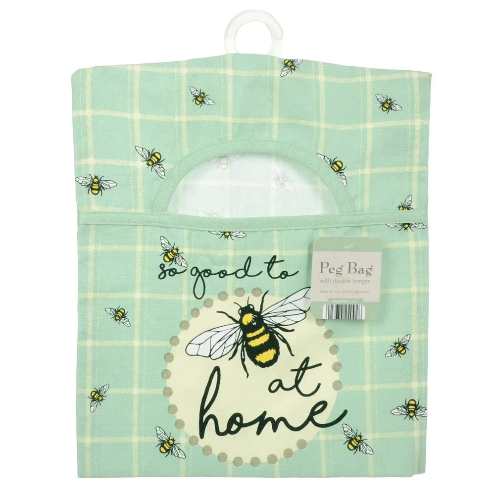 Peg bag with bee design and text 'So good to be at home' on a green checkered background.