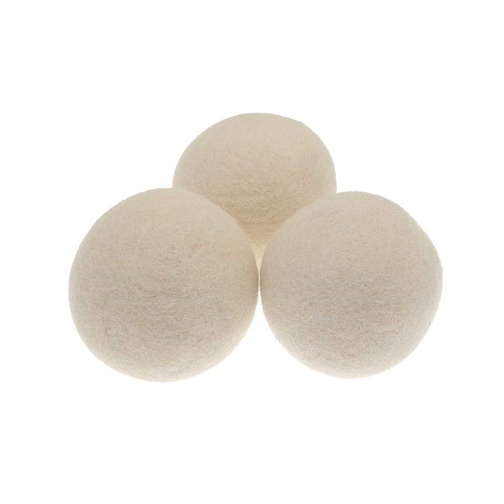 three white wool tumble dryer balls side by side on white background