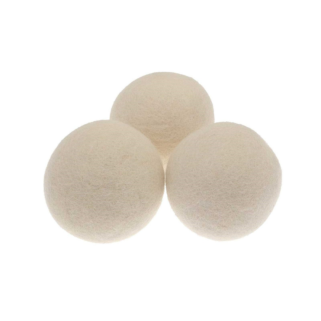 three white wool tumble dryer balls side by side on white background