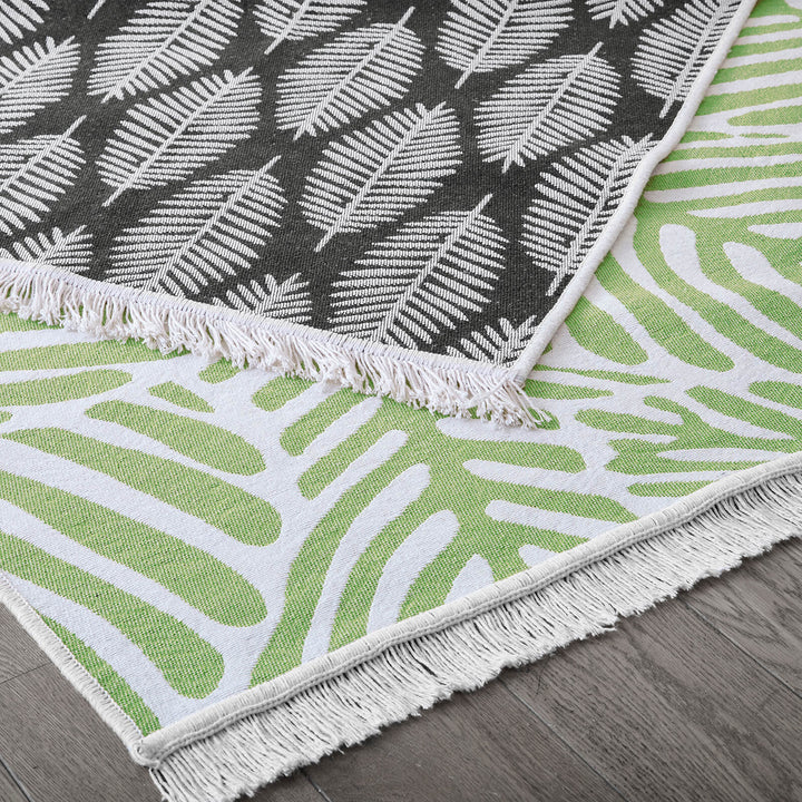 Green and white leaf pattern reversible rug with black fern design back