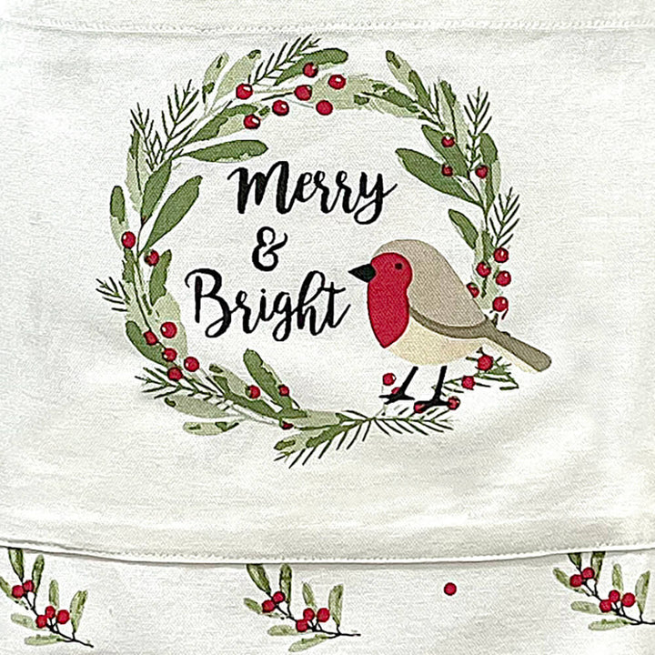 Close up of Christmas robin with Merry &amp; Bright text on a festive apron pocket