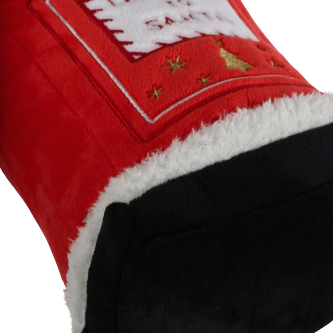 Close-up of a red Christmas door stop with white faux-fur trim, a black cuff, and gold embroidered stars and a small tree on a white background.