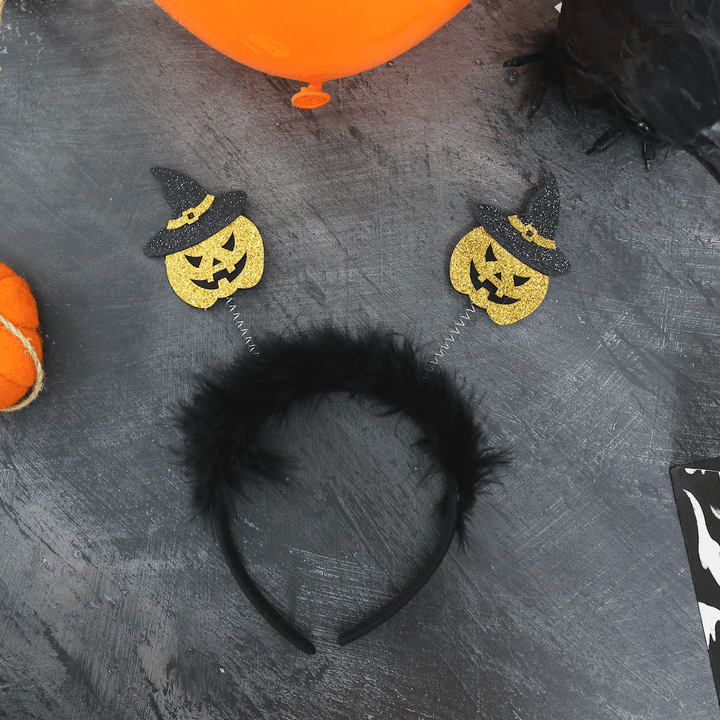 black pumpkin head boppers with furry trim on black background with orange balloons