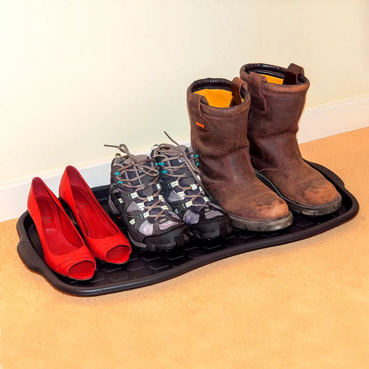 Boots and shoes sitting on a black tidy tray for keeping carpets clean