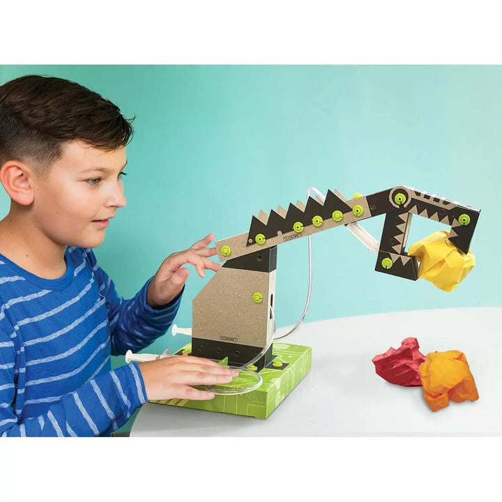 Boy playing with robotic arm to lift and move objects