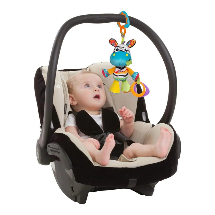 Baby in a car seat looking at a hanging zebra activity toy with bright colours and teething rings