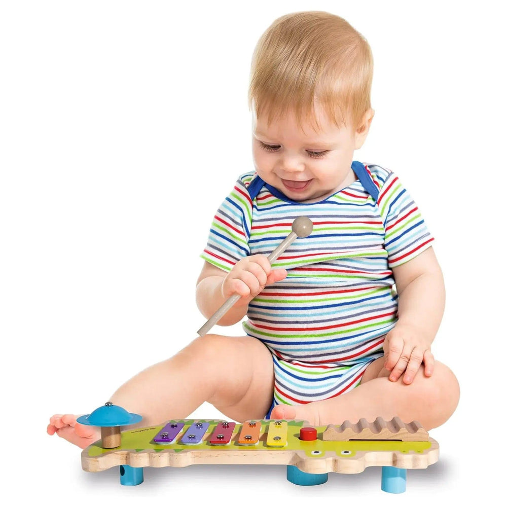 Young child playing with a musical xylophone wooden toy