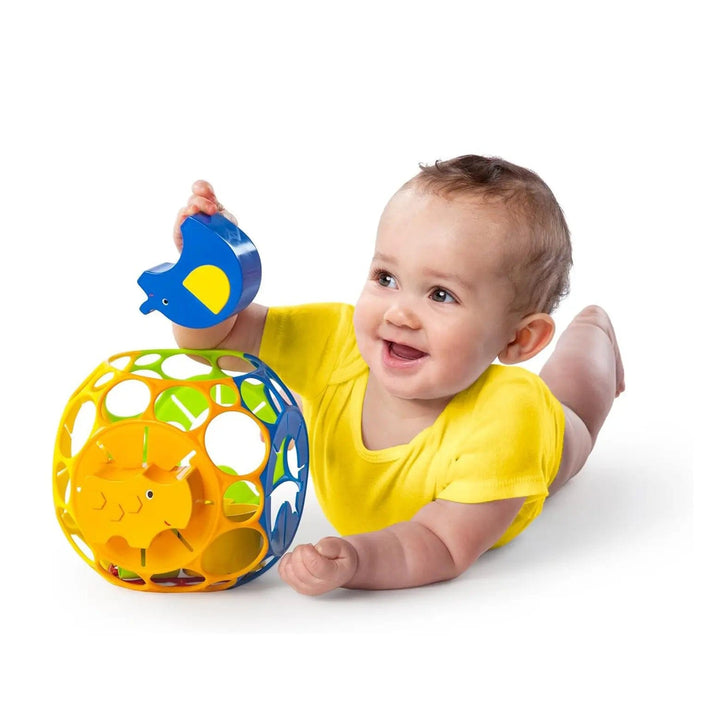 baby on its tummy playing with a ball animal shape sorter