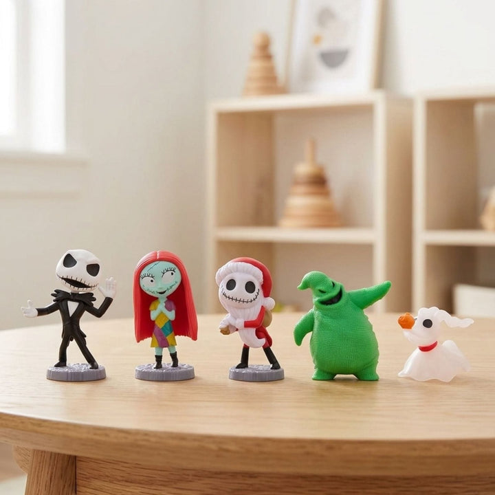 Five small character figurines from The Nightmare Before Christmas are lined up on a light wood table in a softly blurred indoor room. The figures include Jack Skellington, Sally, Zero, Oogie Bookie &amp; Sandy Claws.