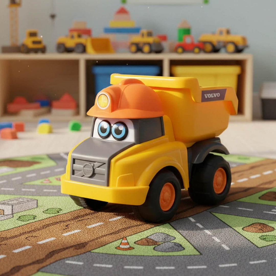 A yellow and orange toy dump truck with cartoon eyes and a Volvo badge, placed on a road play mat in a children's room.