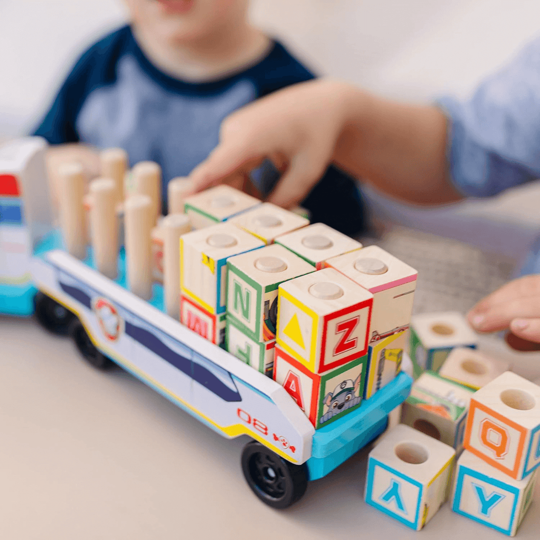 little kids playing with the wooden block truck