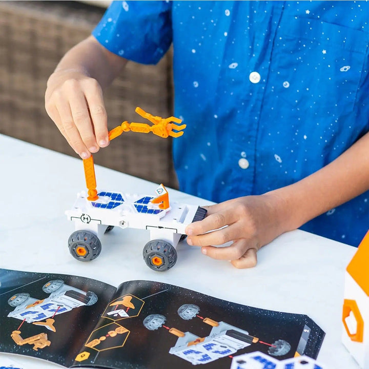 Child building a space rover vehicle with crane arm