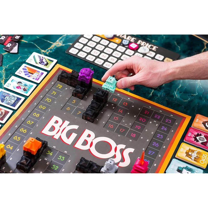 Board game 'Big Boss' with player hand interacting with game pieces on a green marble surface.