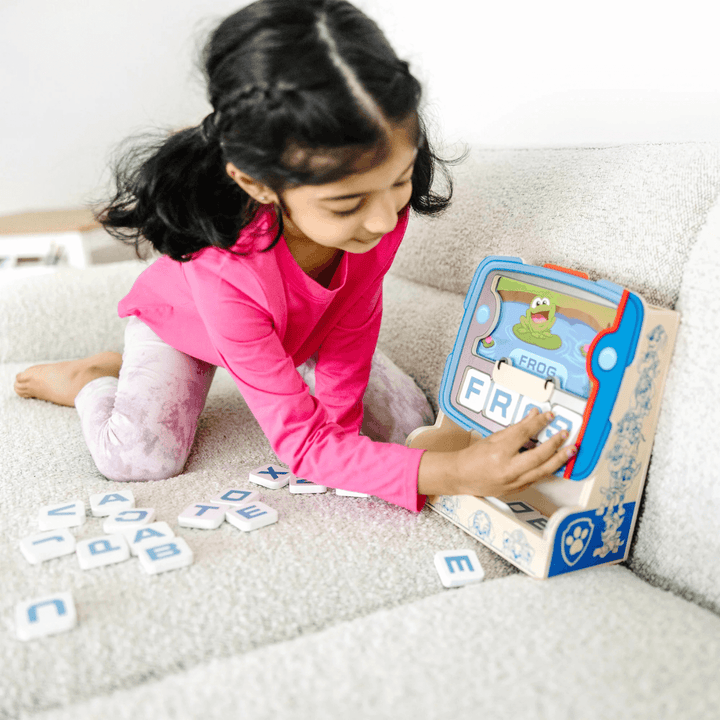 little girl uses letters to spell the words on the screen display &
